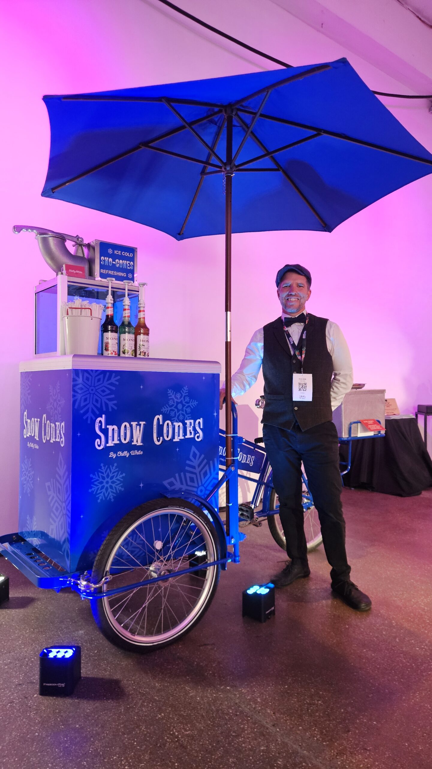 Christmas-themed snow cone cart serving festive shaved ice treats at a winter event with seasonal decorations and professional staff.