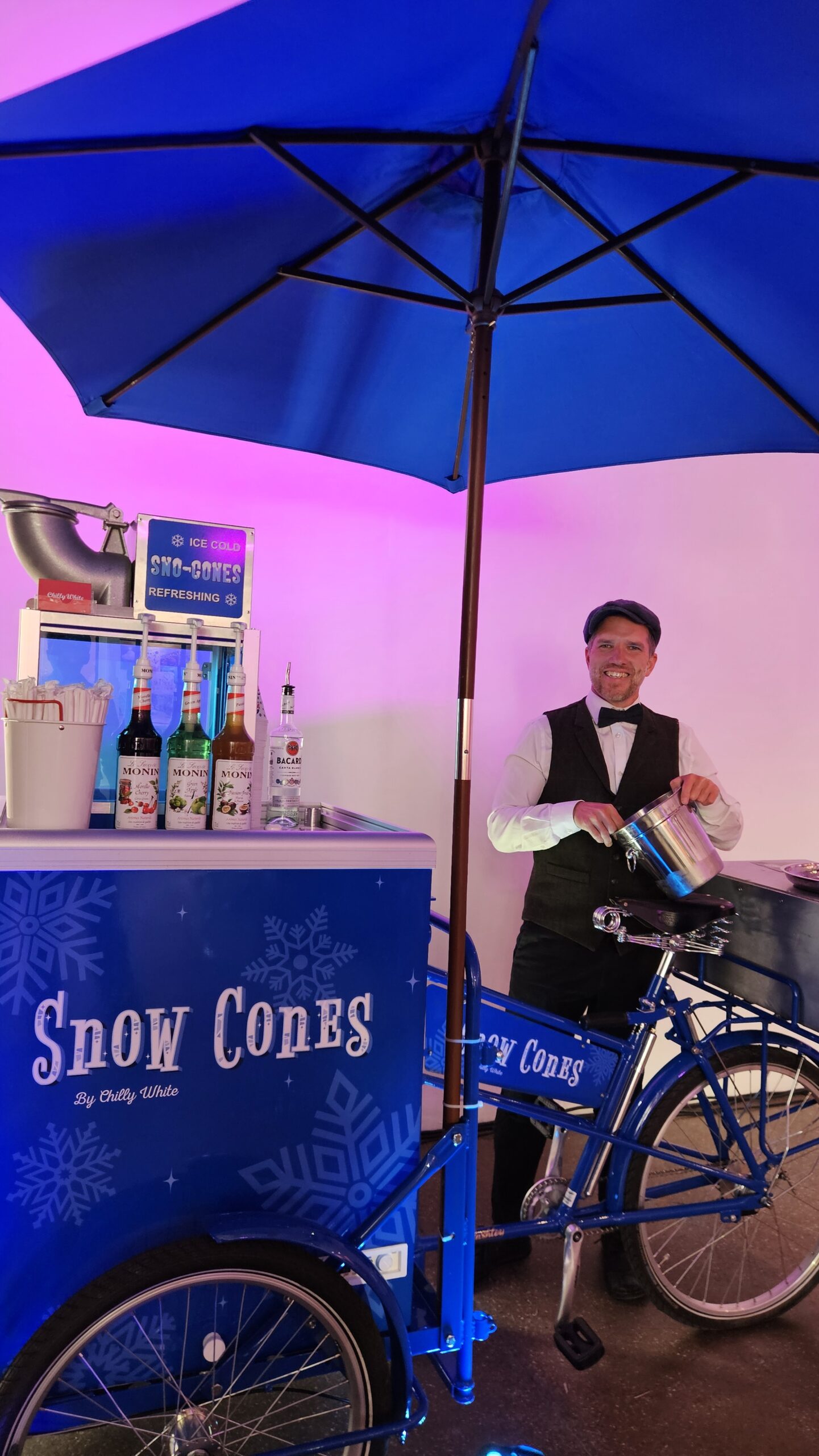 Christmas-themed snow cone cart serving festive shaved ice treats at a winter event with seasonal decorations and professional staff.