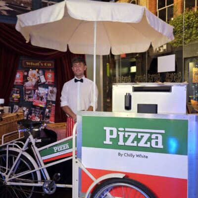 Wood-fired pizza chef serving freshly baked artisan pizzas from Chilly White’s luxury mobile pizza catering service at a UK event