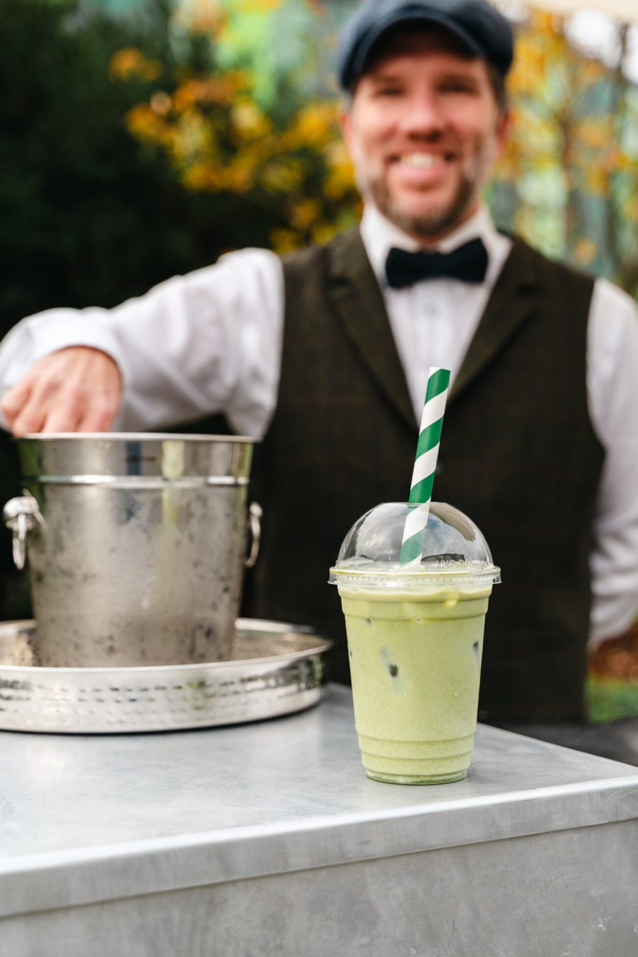 Refreshing matcha latte outdoors with a striped straw.