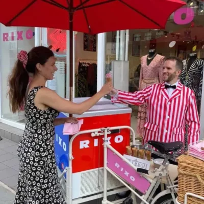 Luxury branded ice cream tricycle serving a customer outside a retail store at a UK brand activation event with professional ice cream vendor and premium mobile catering by Chilly White